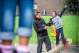 Leerkracht begeleidt leerling op balk op speelplaats